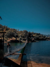 Scenic view of lake against clear blue sky