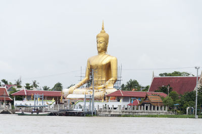 Statue in front of temple against clear sky