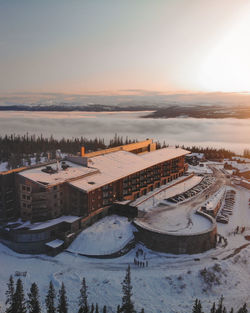 High angle view of snow covered buildings against sky during sunset