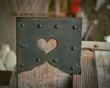 Close-up of padlock on wooden railing