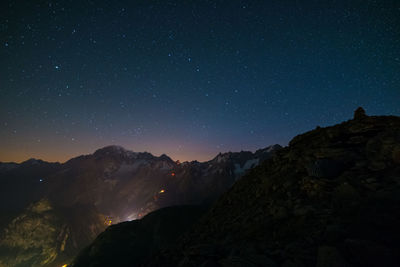 Scenic view of illuminated mountains against sky at night