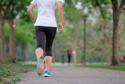 Low section of woman walking on footpath