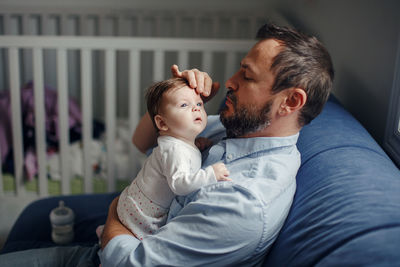 Father with baby sitting at home