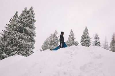 Full length of person on snow covered trees against sky