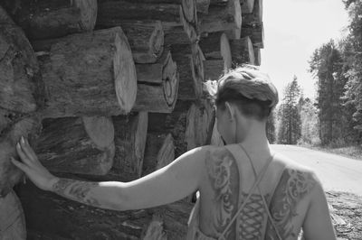 Close-up of woman on log in forest