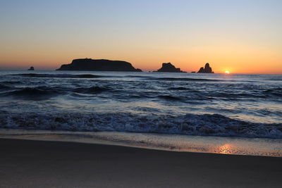 Scenic view of sea against clear sky during sunset