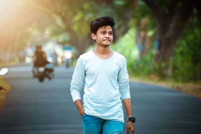 Portrait of young man standing on road