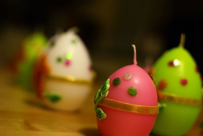 Close-up of easter egg shaped candles on table