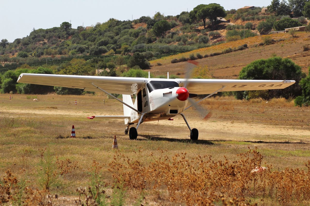 AIRPLANE FLYING ABOVE FIELD