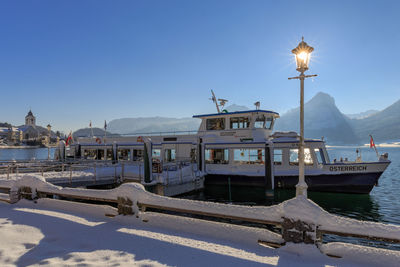 Boats at harbor against clear sky