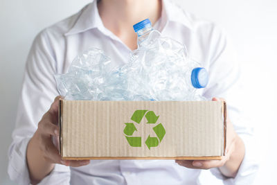 Midsection of woman holding paper in box