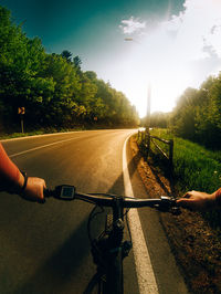 Man riding bicycle on road against sky