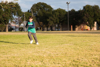 Full length of boy running on grass