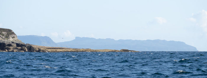 Scenic view of sea and mountains against clear sky