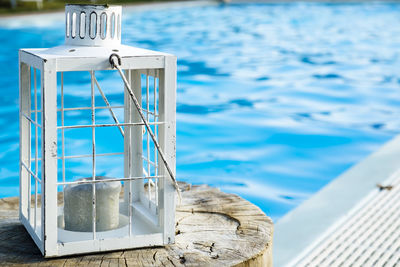 Lantern on tree stump at poolside