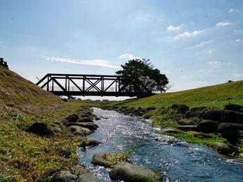 Bridge over rocks against sky