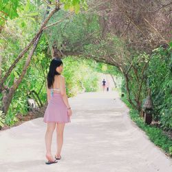 Rear view of woman walking on footpath