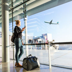 Woman using mobile phone at airport