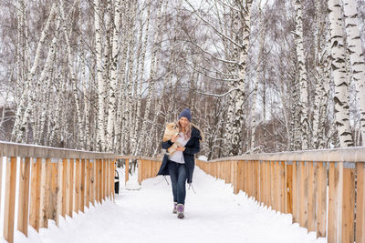 Woman standing on snow covered footbridge