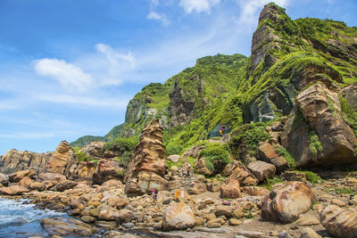 Rock formation on mountain against cloudy sky