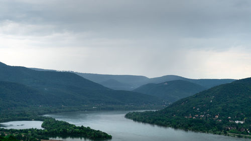 Scenic view of river and mountains against sky