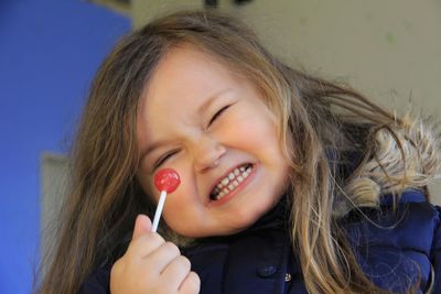 Portrait of cute girl eating lollipop while sitting outdoors