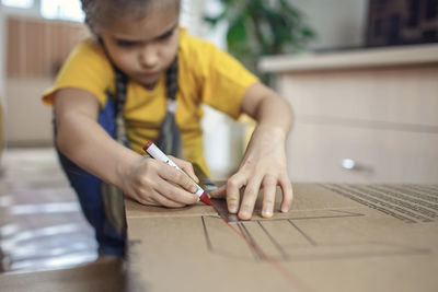 Midsection of boy holding table at home