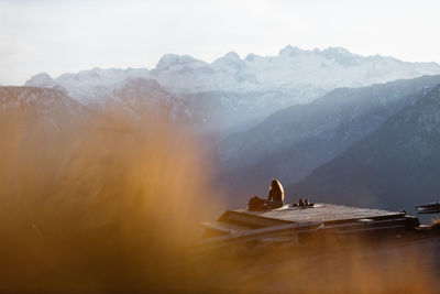 People sitting on mountain against sky