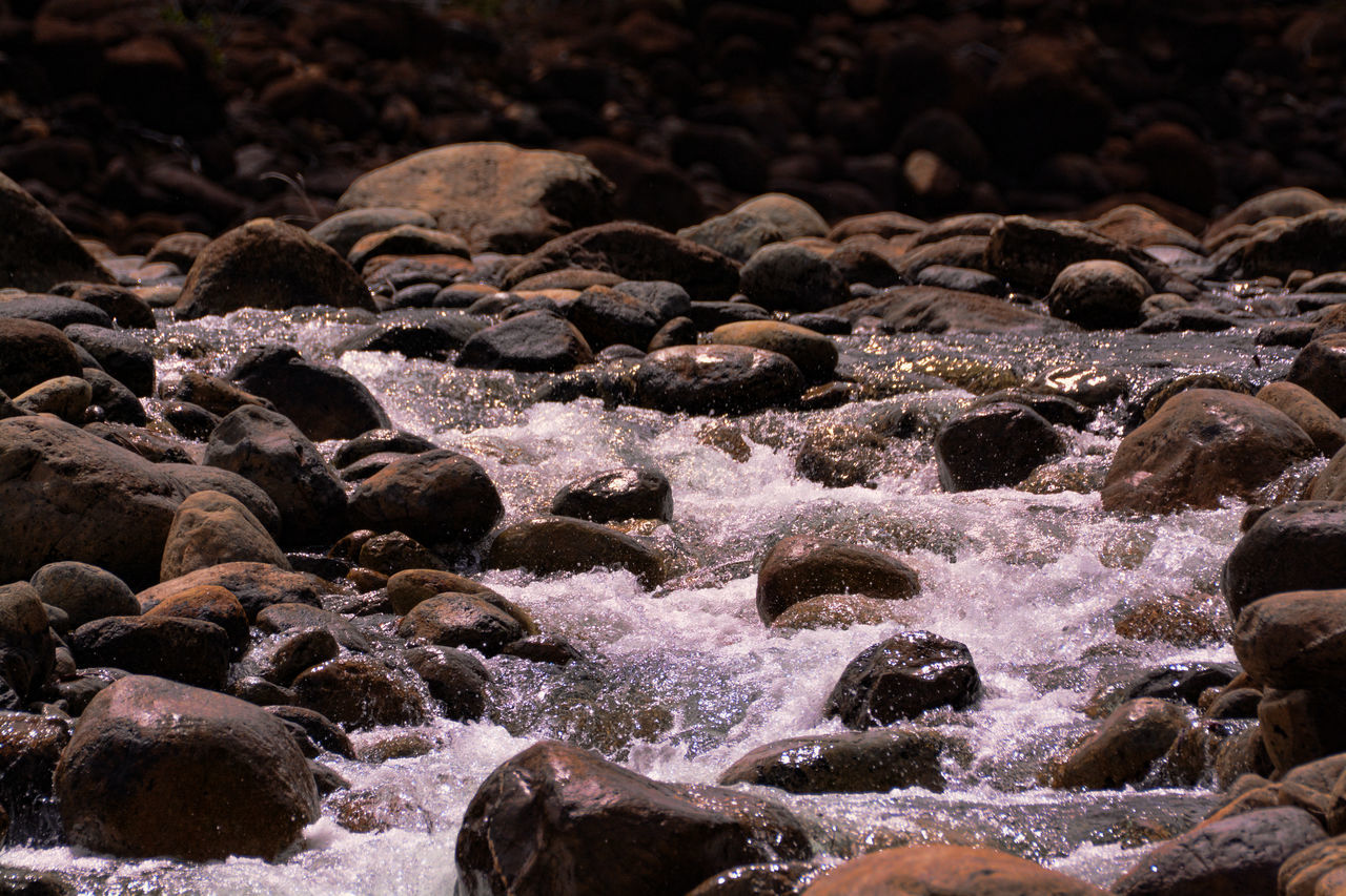 HIGH ANGLE VIEW OF ROCKS ON SEA SHORE