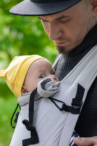 Father carrying his child in a baby sling