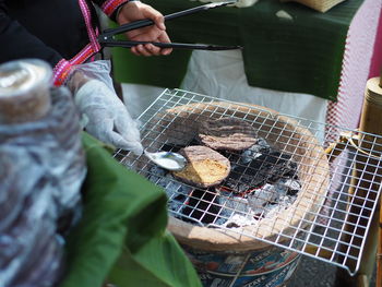 Close-up of preparing food on barbecue grill