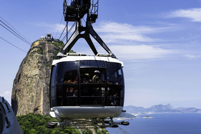 Low angle view of overhead cable car against sky