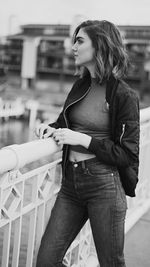 Thoughtful woman standing by railing