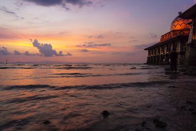 View of beach against cloudy sky during sunset