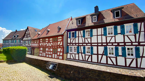 Houses by canal against sky in city