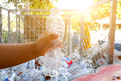 Close-up of hand holding glass bottle