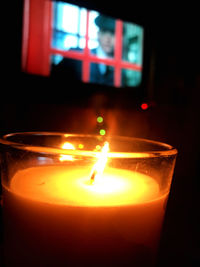 Close-up of lit candle in dark room