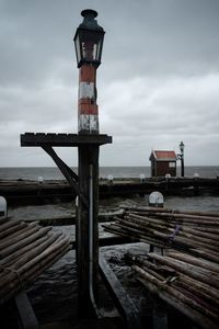 Lifeguard hut on pier by sea against sky