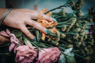 Female hands with blue manicure on a background of fresh flowers