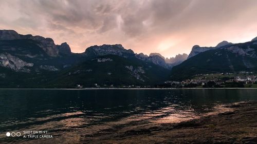 Scenic view of lake by mountains against sky