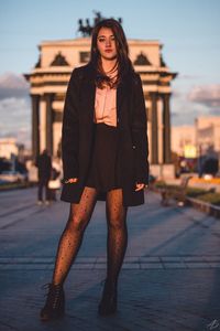 Full length of young woman standing in city