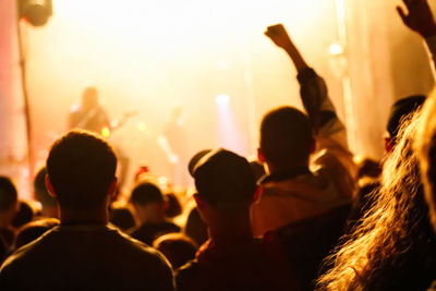 Cheering crowd and stage lights with space for your text. silhouette of people raise hand up 