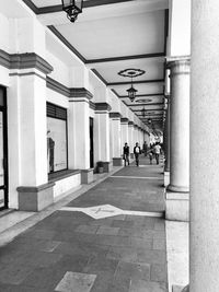 People on footpath amidst buildings in city