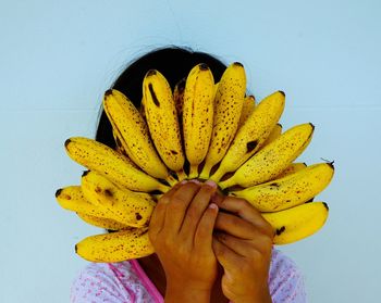 Close-up of hand holding yellow bananas
