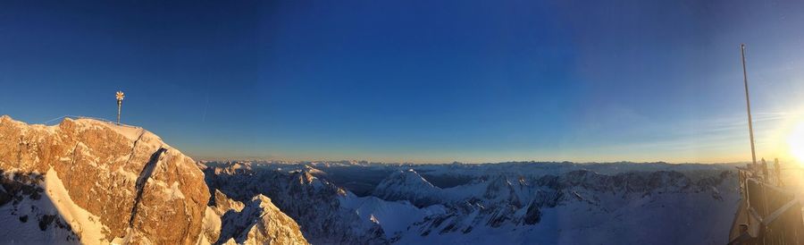 Panoramic view of snowcapped mountains against blue sky