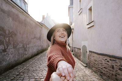 Portrait of smiling woman standing against wall