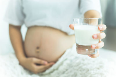 Midsection of person holding ice cream in glass