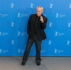 Full length of man standing against blue wall