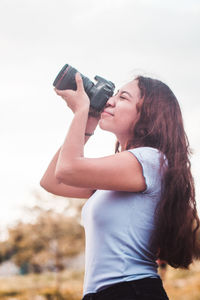 Young woman photographing with camera