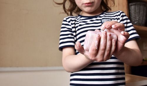 Midsection of girl holding soap